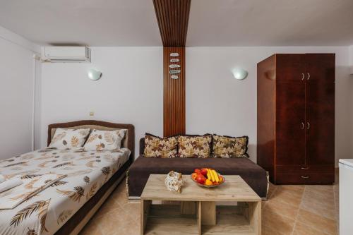 a bedroom with a bed and a table with a cat on it at Mir & More in Budva