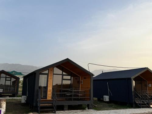 a group of huts in a field with mountains in the background at Tosor Barnhouse in Tossor
