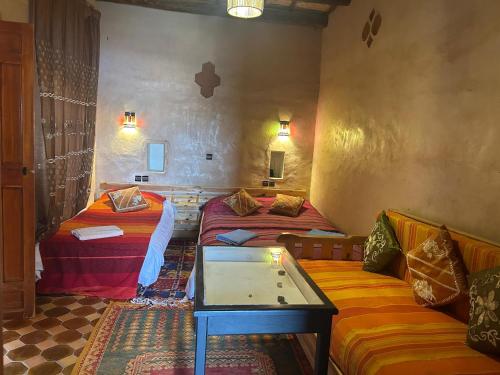 a living room with two beds and a couch at Kasbah Petit Nomade in Tinerhir