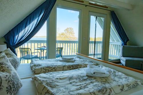 two beds in a room with a balcony at Ferienhaus Seestern direkt am Plauer See in Plau am See