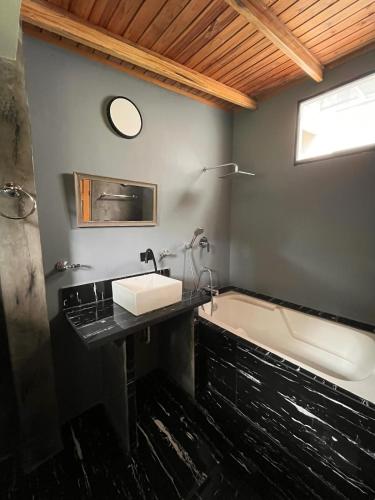 a bathroom with a sink and a bath tub at Refugio de Guacamayas in Mérida