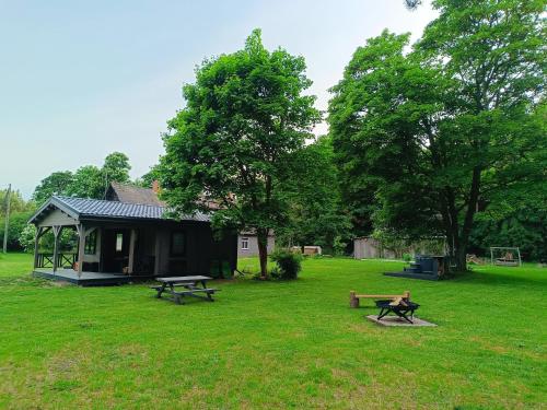 a house with two picnic tables in a yard at Mežmaļi in Jūrkalne