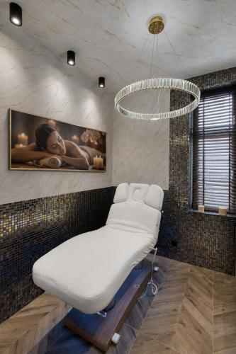 a hospital room with a bed and a chandelier at Monaco Ville Wellness in Międzyzdroje
