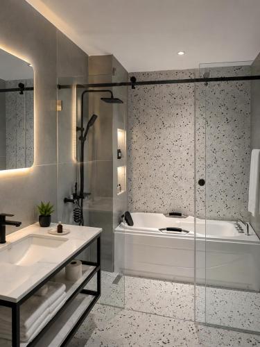 a bathroom with a tub and a sink and a shower at Family House Assinie in Assinie