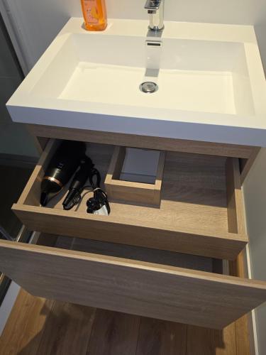 a bathroom vanity with a white sink on top of it at T2 proche gare & centre ville climatisé in Castres