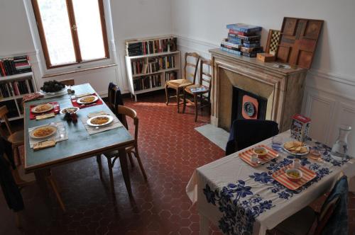 a dining room with two tables and a fireplace at QG Marseille in Marseille