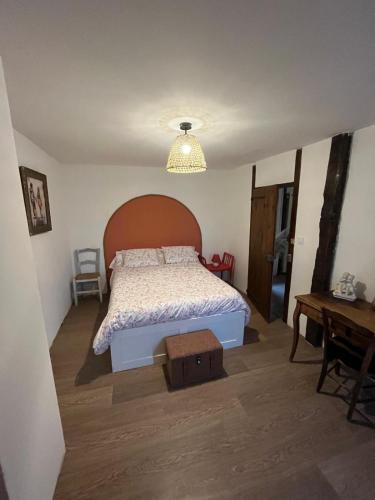 a bedroom with a bed with a wooden headboard and a table at Le Gîte Chez Mémé in Lavelanet