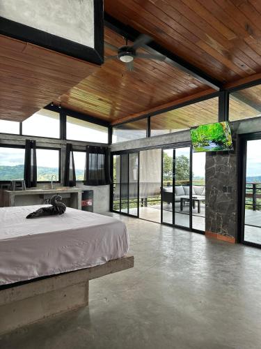 a bedroom with a bed in a room with windows at Finca Mirador De Gualaca in Gualaca