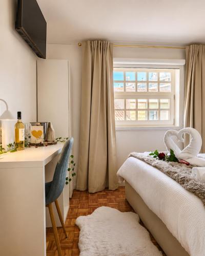 ein Schlafzimmer mit Bett, Schreibtisch und Fenster in der Unterkunft Opus House in Guimarães