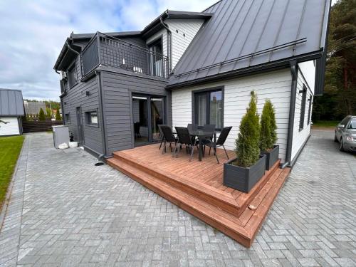 a house with a deck with a table and chairs at Roosi Kodumajutus in Pärnu