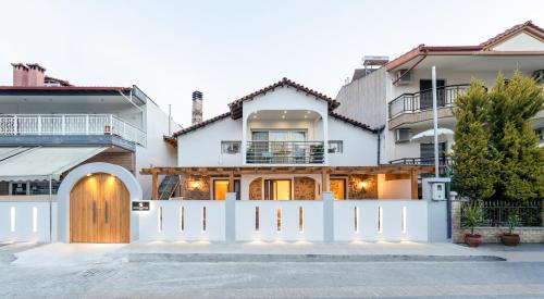 a white fence in front of a house at Mylopetra Suites Sarti in Sarti