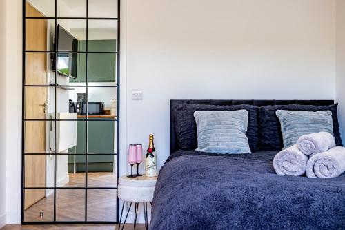 a bedroom with a blue bed with towels on it at The Hide at St Andrews in Fife