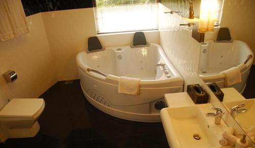 a bathroom with a tub and a sink and a toilet at Vintara Wild Hambanthota in Hambantota