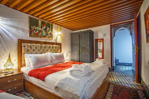 a bedroom with a large bed with towels on it at Riad Iline fes in Fez