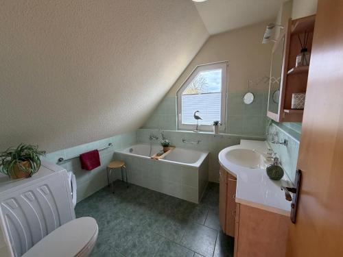 a bathroom with a sink and a tub and a toilet at Ferienhaus Seestern direkt am Plauer See in Plau am See