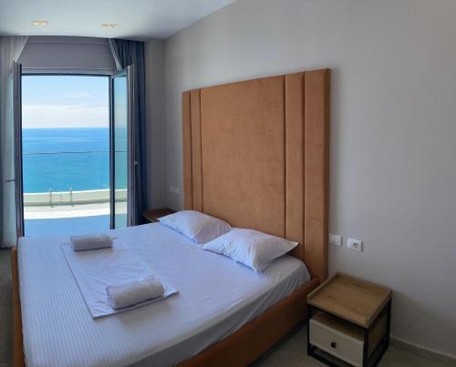 a bedroom with a bed with a view of the ocean at DreamStay Lezha Apartments - Ilyonis Residence in Lezhë