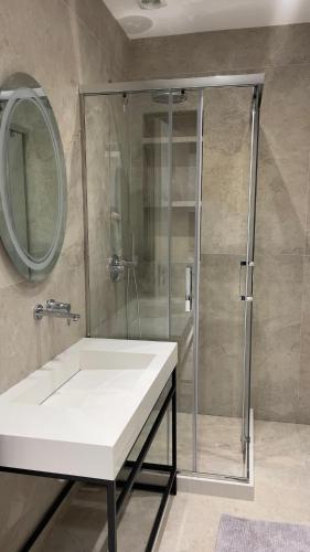 a bathroom with a shower and a white sink at DreamStay Lezha Apartments - Ilyonis Residence in Lezhë