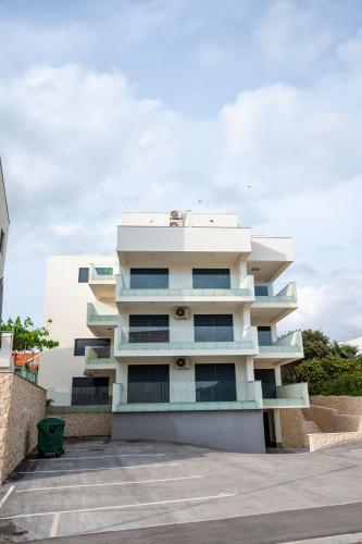 a white apartment building with a parking lot at Apartment 98A7 in Povljana