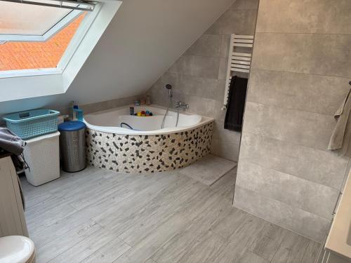 a bathroom with a bath tub in a attic at Modernes Landhaus Modern country house in Kalkar