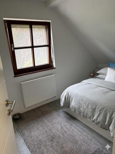 a bedroom with a bed and a window at Modernes Landhaus Modern country house in Kalkar