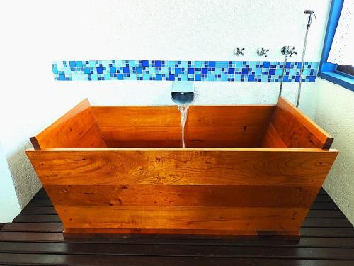 a wooden bath tub with a water fountain at Pousada Vivenda in Tiradentes