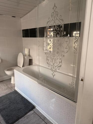 a bathroom with a white tub and a toilet at Cosy Heavens in Quinton