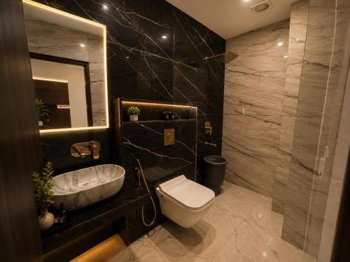 a bathroom with a toilet and a sink and a mirror at Hotel GS Grand Amritsar in Amritsar