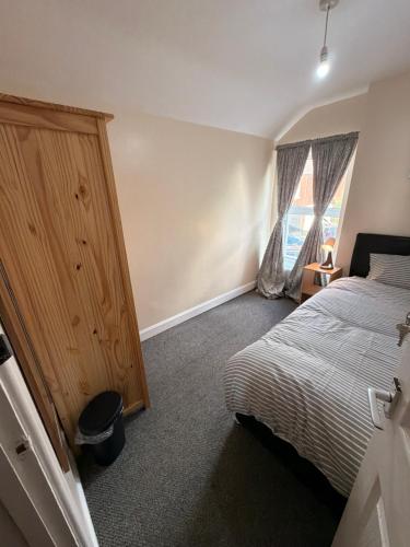 a bedroom with a bed and a large window at Cosy Heavens in Quinton