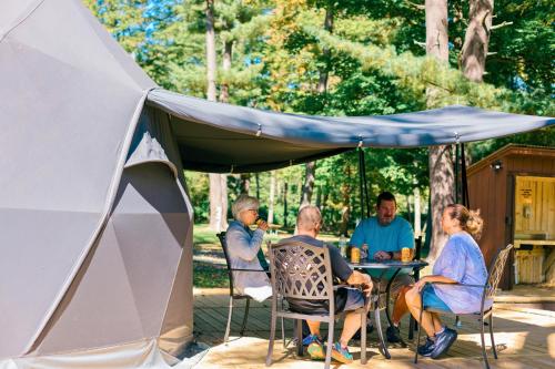 a group of people sitting at a table under a tent at Boutique Glamping Dome in the Catskill Mountains in Gilboa