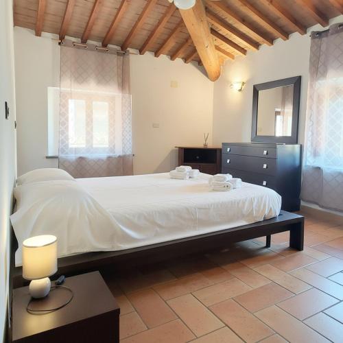 a bedroom with a large bed and a mirror at Rustic Refuge in the Hills in Santa Luce