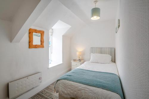 a white bedroom with a bed and a window at 2 Bed in Pwllheli oc-44492 in Nefyn