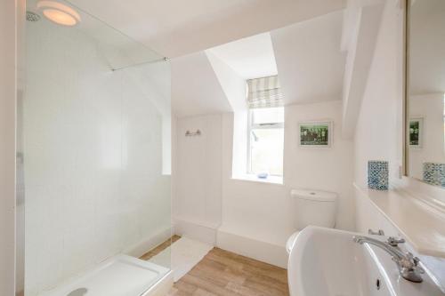 a white bathroom with a toilet and a sink at 2 Bed in Pwllheli oc-44492 in Nefyn