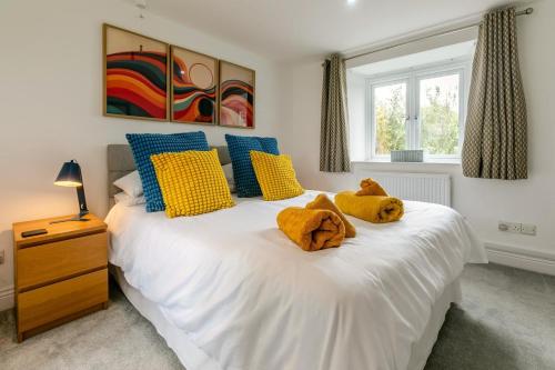 a bedroom with a white bed with yellow and blue pillows at 2 Bed in St. Minver oc-r29475 in Saint Minver