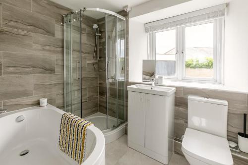 a bathroom with a tub and a toilet and a shower at 2 Bed in St. Minver oc-r29475 in Saint Minver
