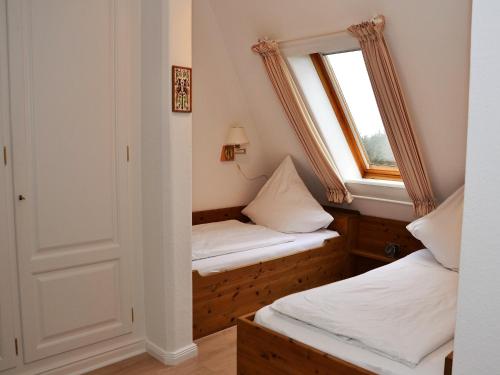 a small room with two beds and a window at Haus Seeflieger in Westerland