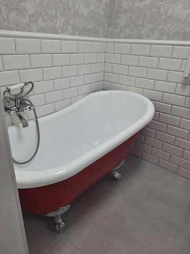 a red and white bath tub in a bathroom at Domek Za Wyspą 3 in Chmielów