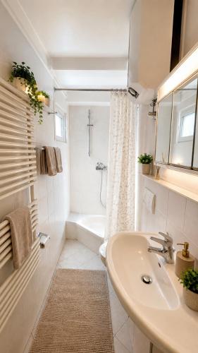 a white bathroom with a sink and a bath tub at unterkunft Cuxhaven in Cuxhaven
