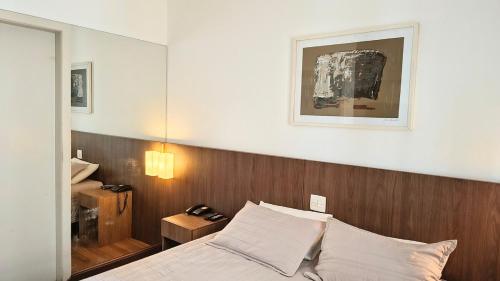 a bedroom with a bed with a wooden head board at Flat Niagara Belo Horizonte in Belo Horizonte