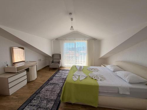 a bedroom with a bed and a desk and a window at Olivra Apart in Cedit