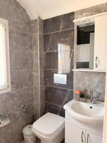 a bathroom with a toilet and a sink at Olivra Apart in Cedit
