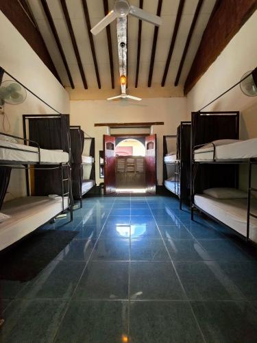 a room with several bunk beds and a ceiling at Poco a Poco Hostel in León