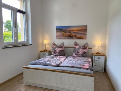 a bedroom with a bed with two night stands and two windows at Kreide & Kissen in Lünebach