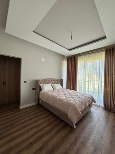 a bedroom with a bed and a large window at Villa suit in Trabzon