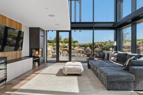 a living room with a large couch and a tv at The Retreat at Strashleigh Manor Farm - A Luxury Devon Country Escape in Ivybridge