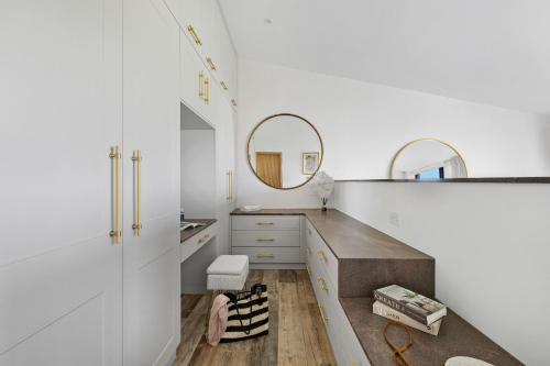 a bathroom with white cabinets and a mirror at The Retreat at Strashleigh Manor Farm - A Luxury Devon Country Escape in Ivybridge