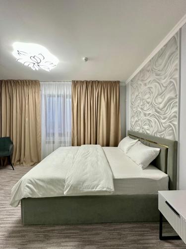 a bedroom with a large bed in front of a window at Karibi in Kyzylorda