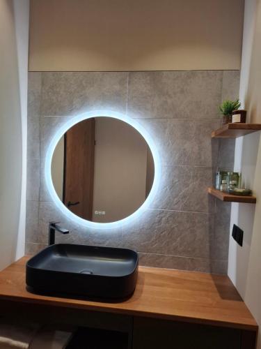 a bathroom sink with a round mirror on a counter at Wald & Wiese Hornstein in Hornstein