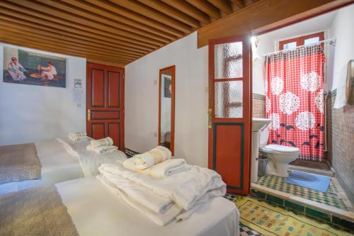 a room with three beds and a toilet at Riad Iline fes in Fez