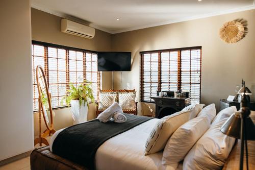 a bedroom with a bed and two windows at Cwebile Guesthouse in Winterton