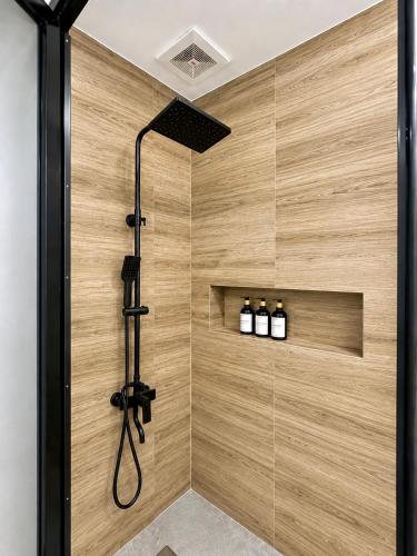 a bathroom with a shower with three bottles of wine at The Penthouse With Outdoor Jacuzzi Private Rooftop Solar Powered Energy in Puerto Princesa City
